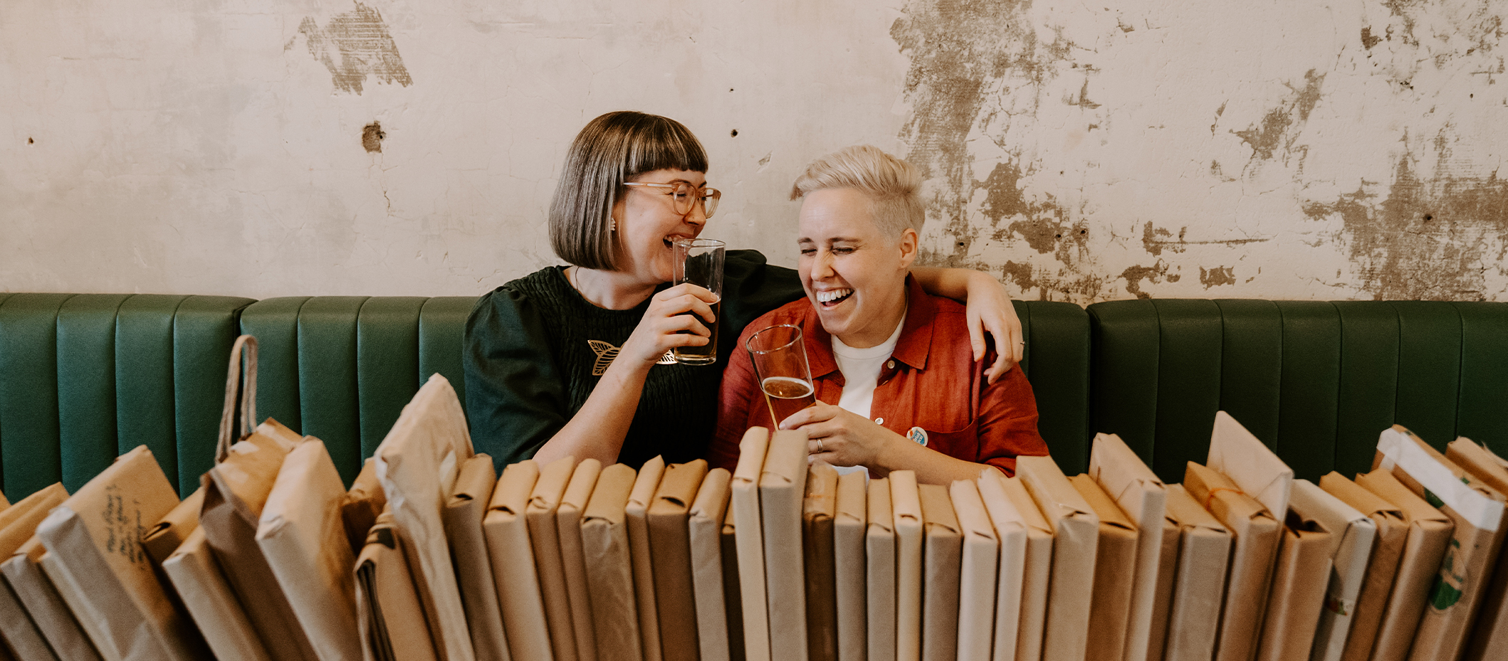 Chrissie & Kel being so cute holding beers and sitting in front of wrapped books.